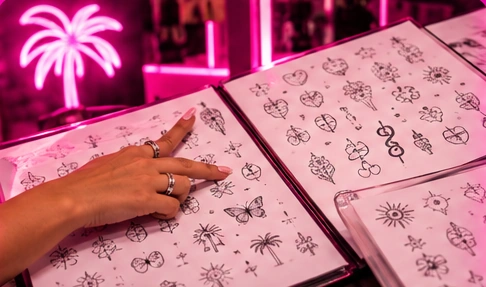 Open flash-design catalogue filled with small tattoo designs